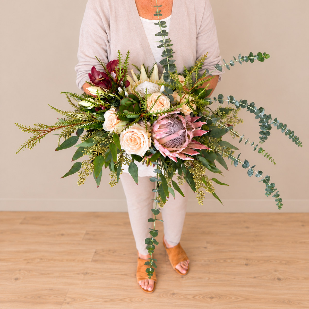 Bridal bouquet with Blushing Bride proteas, Sahara roses, white and regular King proteas, and eucalyptus, made for a mountain wedding